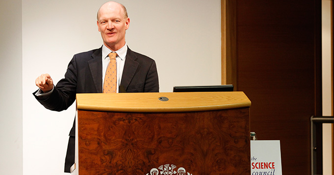 David Willetts MP standing at a podium delivering a lecture