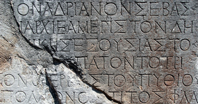 a grey stone tablet with Greek letters engraved
