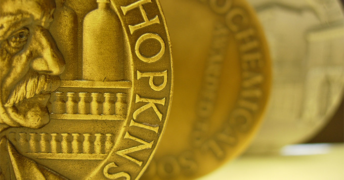 Photo of half a gold coin with the word 'Hopkins'