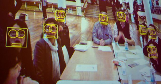 Image of a group of people looking into a camera showing their facial recognition
