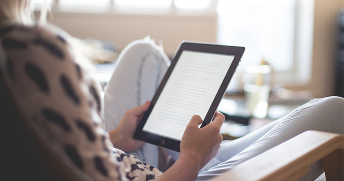 Reading from a tablet while sitting on a chair