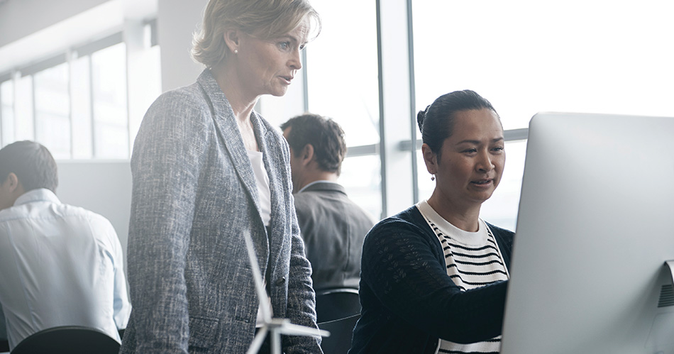 Two women looking at a computer screen in an office