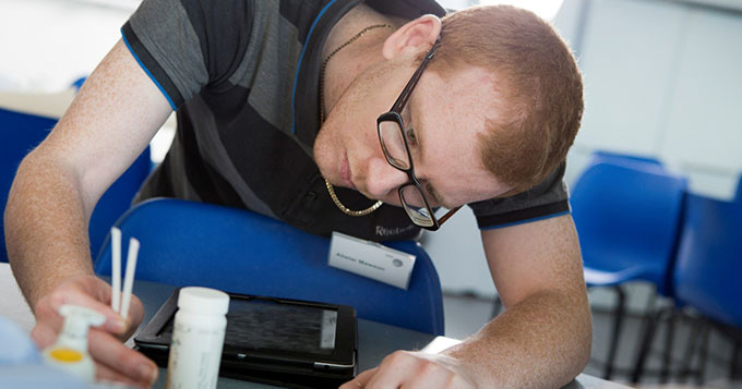 Male apprentice technician taking swab samples