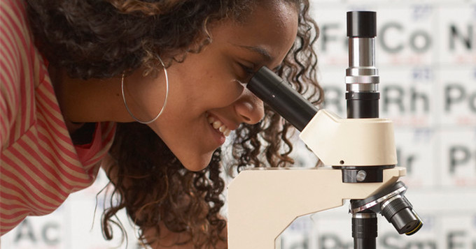 Girl looking through a microscope