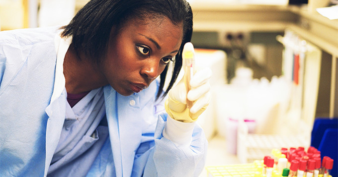 Female scientist looks at a test tube in a lab