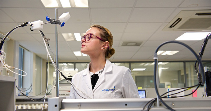 Scientist Karolina RSci checking a machine in the lab