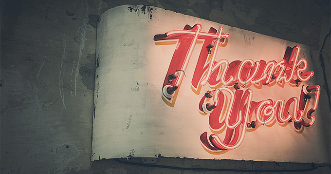 Thank you sign in neon lights against a dark wall