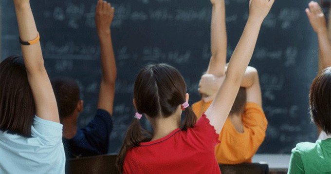 classroom of children wearing different coloured shirts