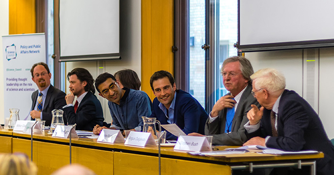 seven people at a table laughing and engaging in debate