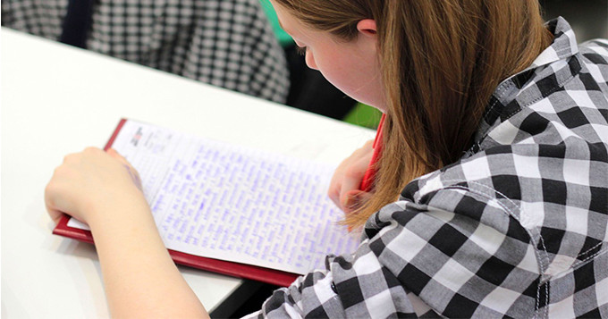 Female student sitting in a lecture writing notes