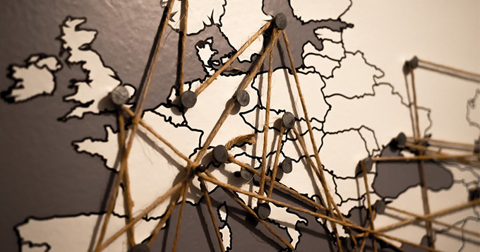 Map of Europe with strings pinned on key places to create a network linking to each other