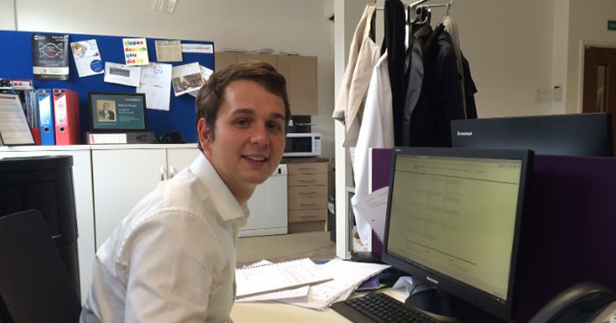 Photo of Science Council Intern, Alex, sitting at his desk in the office