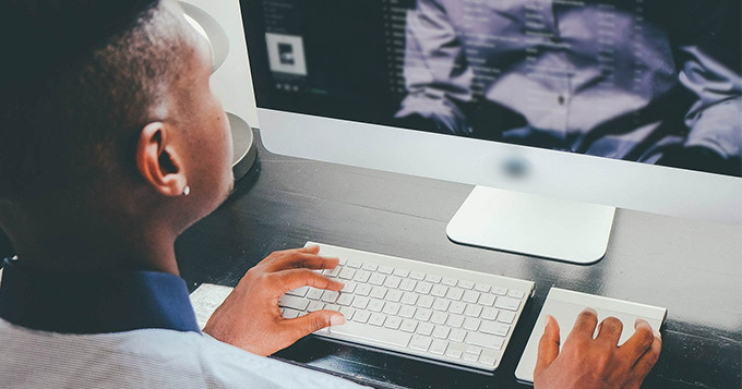 Computer scientist sitting at a desk working on his computer