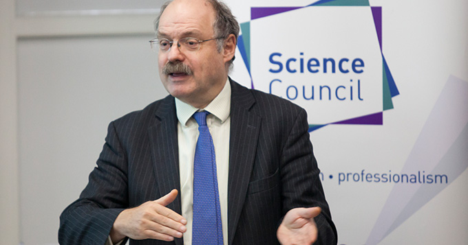 Sir Mark Walport standing in front of Science Council banner