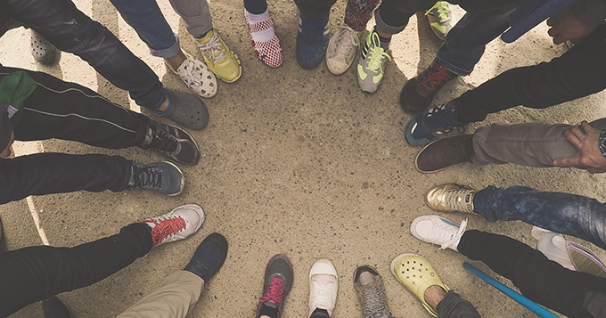 Circle of people with one foot in the centre