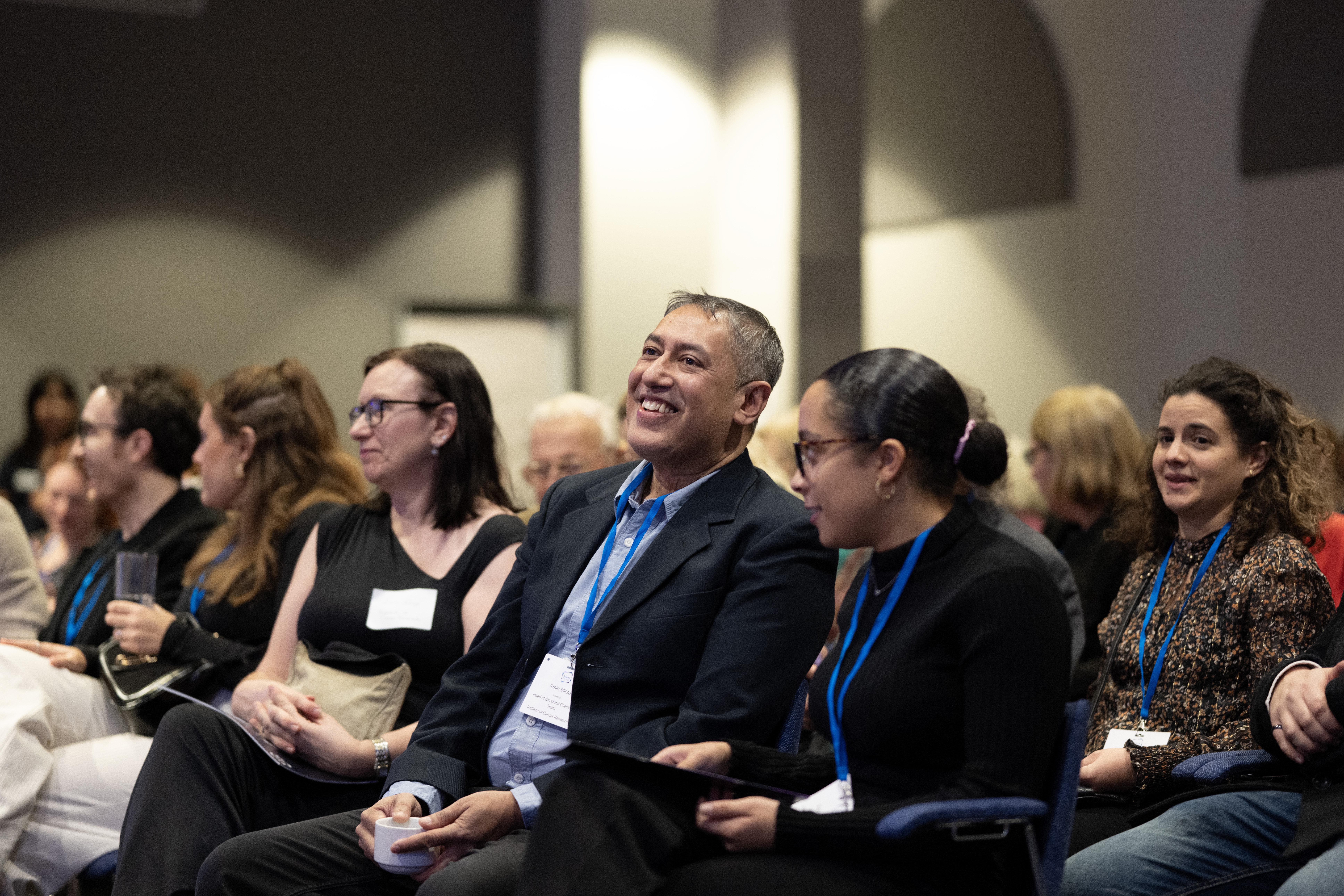 Image focused on three people laughing while waiting for walk to begin on stage.